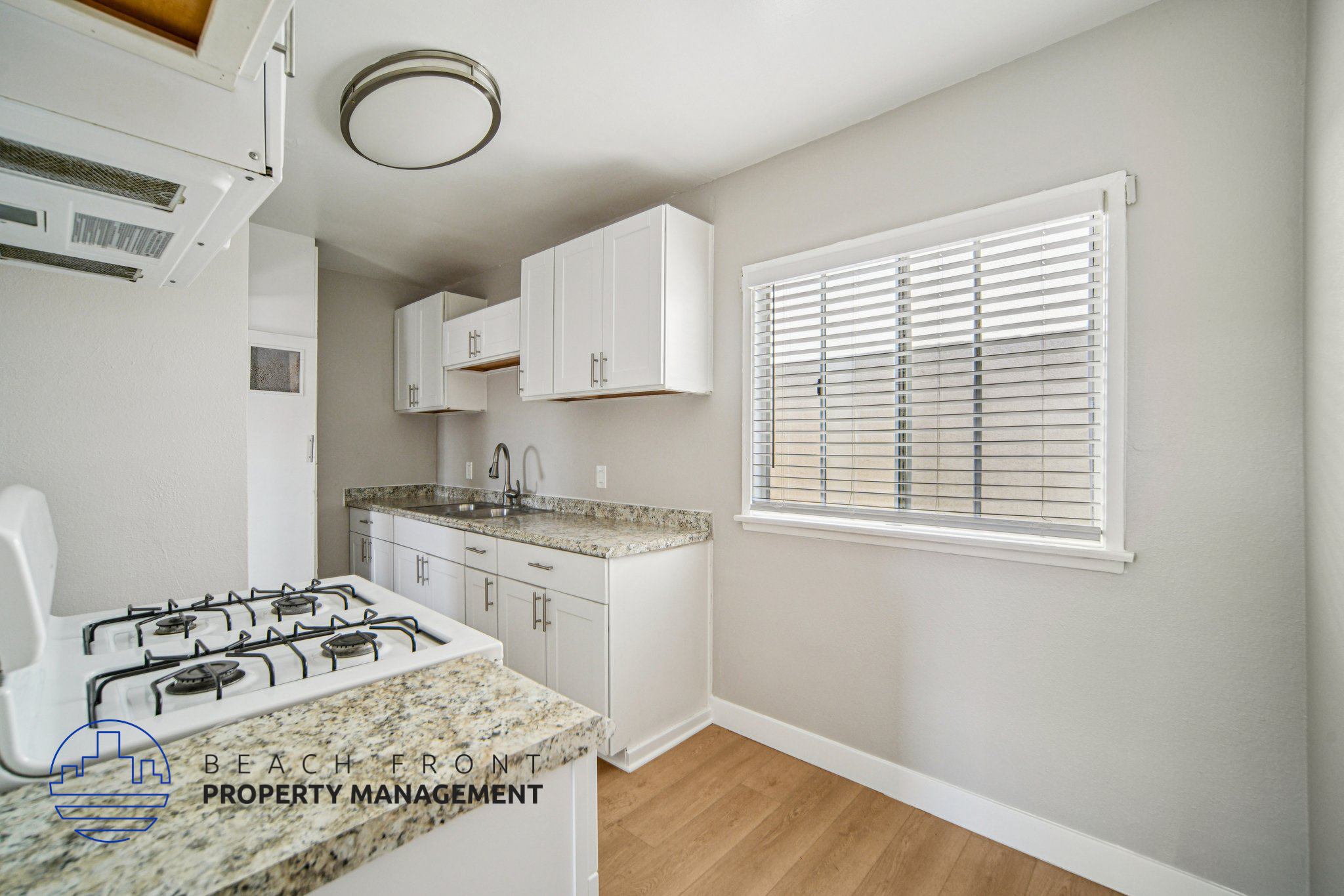 A kitchen with a granite countertop and white cabinets.